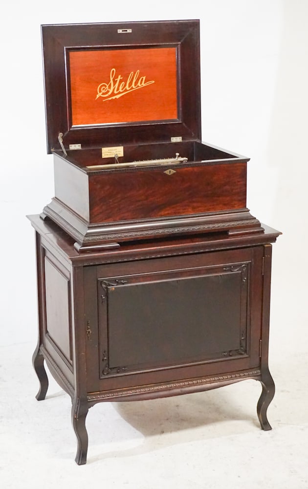 Original Stella Music Box on Stand/Disc Cabinet: Late 19th century disc music box atop original cabinet having disc within the case. The piece is well cared for and in good working order. Good overall condition. H43" D24" W31" (with stand)