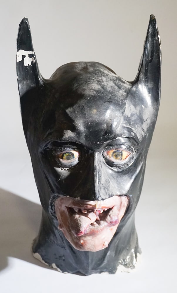 Vintage Folk Pottery Sculpture Bust of Batman: 20th century. Whimsical sculpture of batman having been fired and glazed. Some scattered flaking to glaze and base. One horn has been broken and reattached, very interesting example. H15" Sold from th