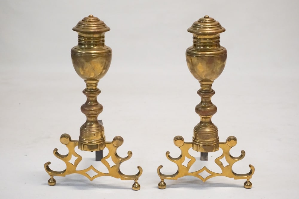 Antique English Spun Brass Andirons: 19th century. Bold pair having strong turning over pierced and scrolling legs with iron log support at back. H21" W12" D14" Sold from the collection of a Lowcountry, South Carolina gentleman.
