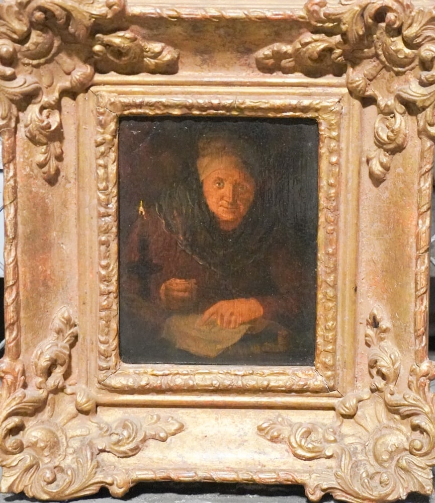 European School: 18th century. Oil on board portrait of a figure reading by candlelight. Nicely rendered and housed in a handsome carved and gilt frame. The piece has an early typed note on verso giving a description.