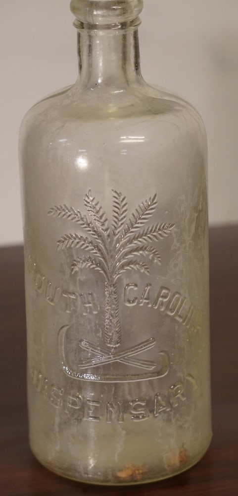Fine Antique South Carolina Cylinder Dispensary Bottle: Circa 1895. Having excellent form and nice bold palmetto seal. Good condition throughout no restorations or cracks. H9 1/2" Sold from the collection of a South Carolina gentleman.