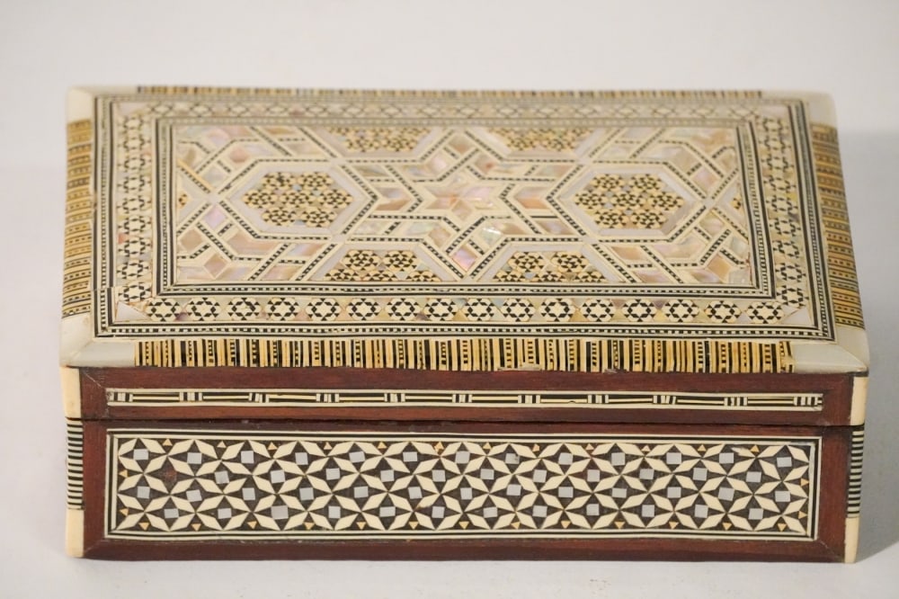 Intricately Inlaid Persian Jewelry Box: 20th century. Brilliantly detailed example, inlaid with bone and mother of pearl. W8 1/8" D5" H2 3/4" Sold from the collection of a West Columbia, South Carolina family.