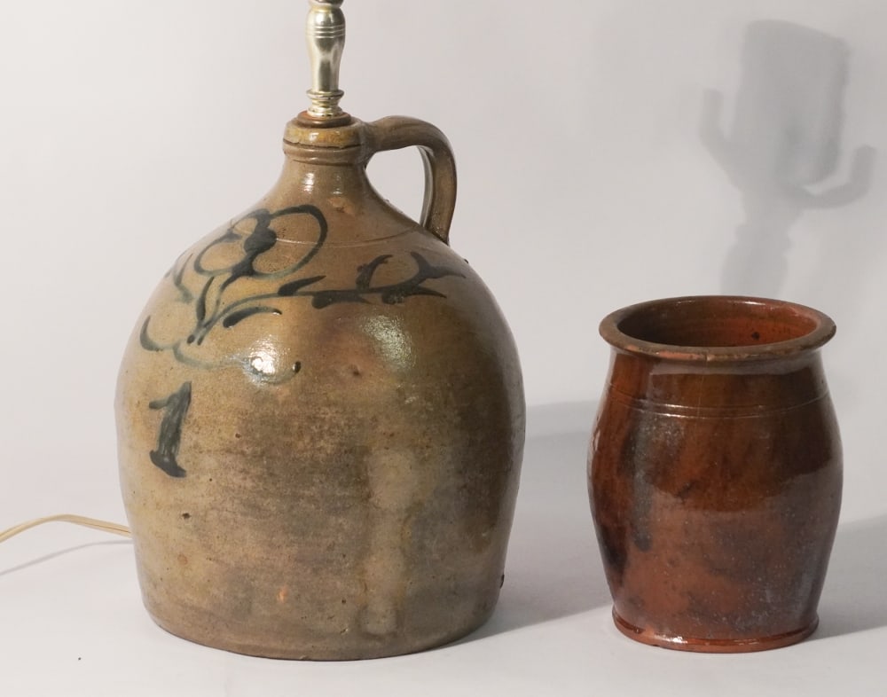 Antique American Decorated Stoneware Jug Along with Redware Storage Jar: 19th century. The lot includes a handsome salt glazed cobalt decorated jug together with a redware preserve jar having manganese spots surrounding the body. The jug is drilled as a lamp and in well fu