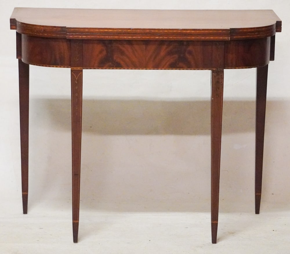 Excellent American Federal Inlaid Mahogany Games Table: Circa 1800, likely Rhode Island. Well grained example having nice fine inlay and banding at the case and legs which are tapered well and centered with elegant bellflower inlay. H29 1/2" W34" D18" Sold