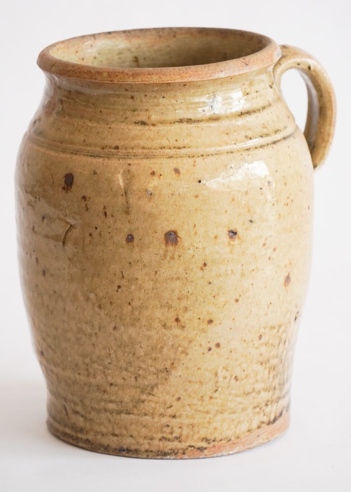 Very Fine Southern Stoneware Single Handled Jar: Circa 1880 attributed to the Landrum Pottery Operation of Columbia, South Carolina. Excellent and nicely formed example having brilliant rich glaze with iron spots and runs. The piece having an uncomm