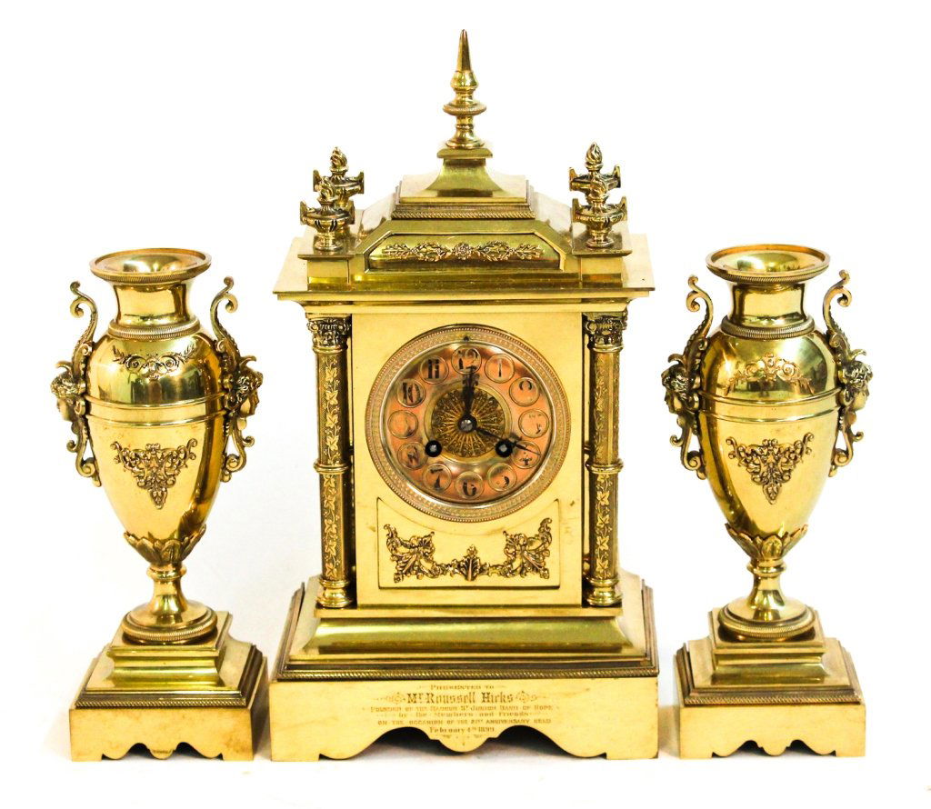 French 3-piece brass clock garniture: Paris, late 19th century. presentation case with finials and full columns housing eight-day time and strike movement, together with matching urns. H15 W8 1/4""