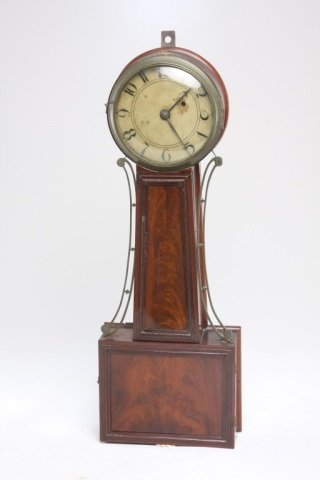 Federal mahogany banjo clock: probably Massachusetts, circa 1835. of typical form, with mahogany throat and door panels, housing eight-day weight-driven movement. H32" W10 3/4"