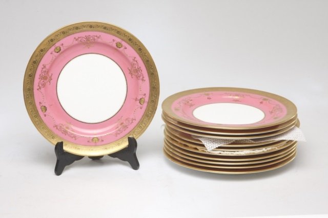 Twelve piece set of Minton Porcelain dinner plates: English. with a white circular center surrounded by a pink ground with gold decoration. gold rim with raised detailing. printed and impressed marks on reverse. retailed by the Gilman Collamore Co. of 