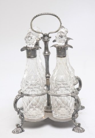 Fine English sterling and cut glass cruet set: 19th century. set is complete with a stand and four faceted cut glass bottles in the George II style. sterling stand and bottle tops bear the mark of Thomas Bradbury & Sons of Sheffield, England. 18.4