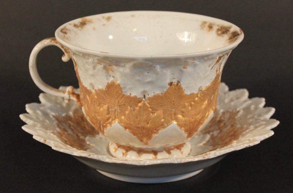 Meissen Porcelain Cup and Saucer: leaf pattern, with gilt decoration on the cup and saucer. underglaze blue crossed swords mark. H4” Dia. 6 ½”