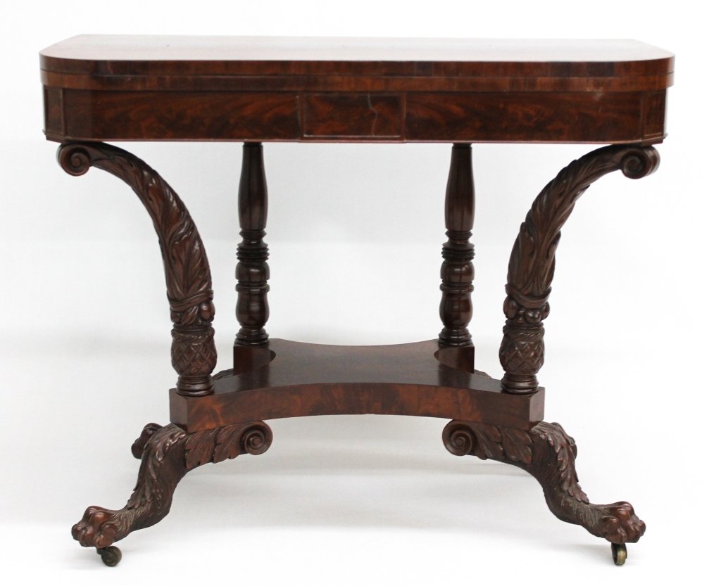 New York Classical Games Table: school of Duncan Phyfe, circa 1820. rotating fold-over top supported by sweeping carved columns with carved hairy-paw feet. H29 7/8" W36" (open) D36" From the Private Collection of Mr. Carl Butler, Cl