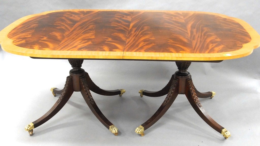 Baker Furniture Inlaid Mahogany Dining Table: shaped and banded rectangular top, with two leaves on two carved pedestals with carved saber legs. H29" W46" L102 1/2" From the Private Collection of Mr. Carl Butler, Clayton, Georgia.