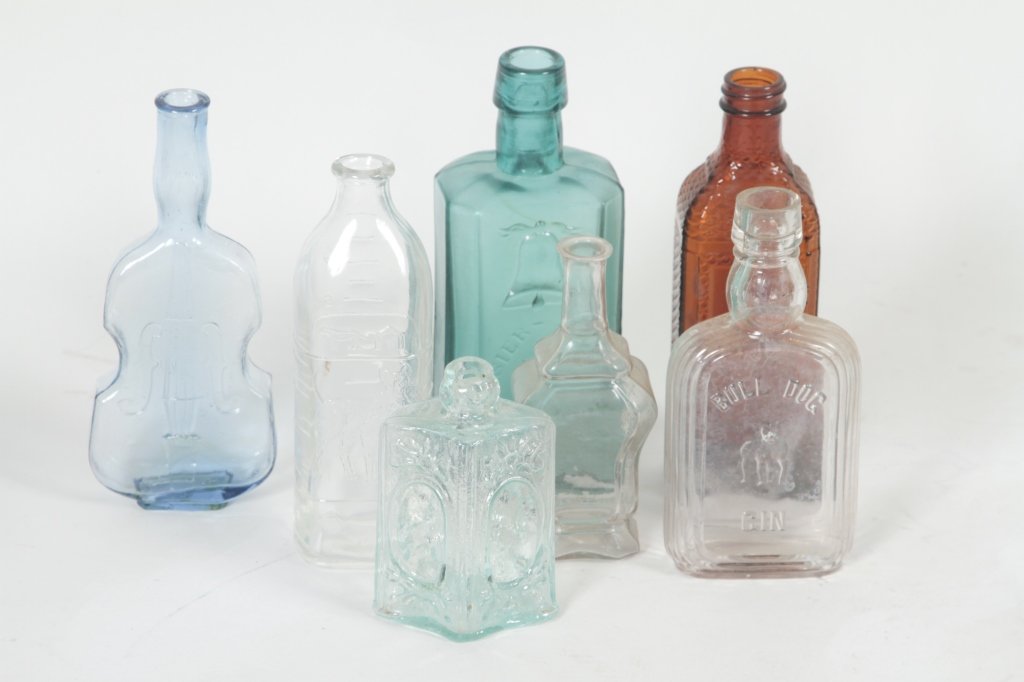 Seven Old Bottles: includes small violin bottle, light blue, H7 1/4"; nursing bottle embossed with dogs, H6 3/4"; aqua bottle embossed "Telssier-Prevost-A. Paris" H7 1/2"; unusual panelled bottle with Indian figures, H4