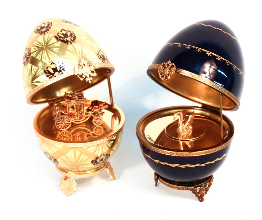 Two Limoges Porcelain Faberge Eggs: 20th century. number 2 “Coronation Egg” gilt-decorated with imperial eagles on a yellow body, a red coach and Faberge marks at gold-wash interior. together with a gilt-decorated, blue porcelain mu