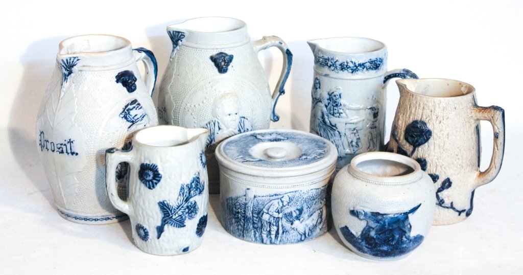 Seven White's of Utica Pottery Items: seven molded stoneware items including five pitchers, cake crock and jar. Hto11" From the Estate of Anita Hill, Jupiter, Florida.