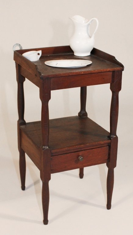 Sheraton Miniature Mahogany Washstand: 19th century. top, with shaped gallery and basin cut-out above medial shelf with single drawer, on turned legs; together with proportional porcelain wash bowl, pitcher and mug. H12" W6 1/4" D6 1/4" Pr