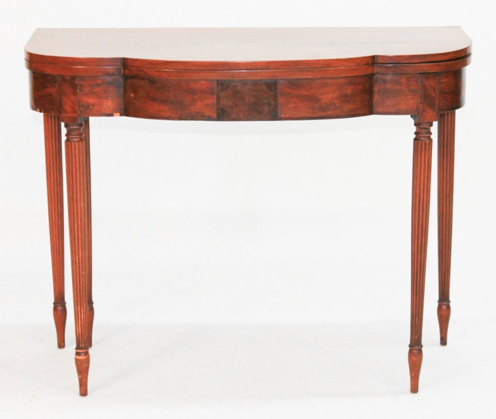 Federal Mahogany Card Table: School of Duncan Phyfe, New York, circa 1810. shaped top above conforming frieze supported by reeded legs with fifth leg swinging to support top. H28 1/2" W36 1/2" D35 1/4" (open)