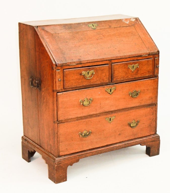 Small George III Oak Campaign Desk: late 18th century. slant-lid desk with interior drawers and pigeon holes above two short drawers over two long drawers, on bracket base with side mounted iron carrying handles.H36" W31 1/2" D18 1/2"