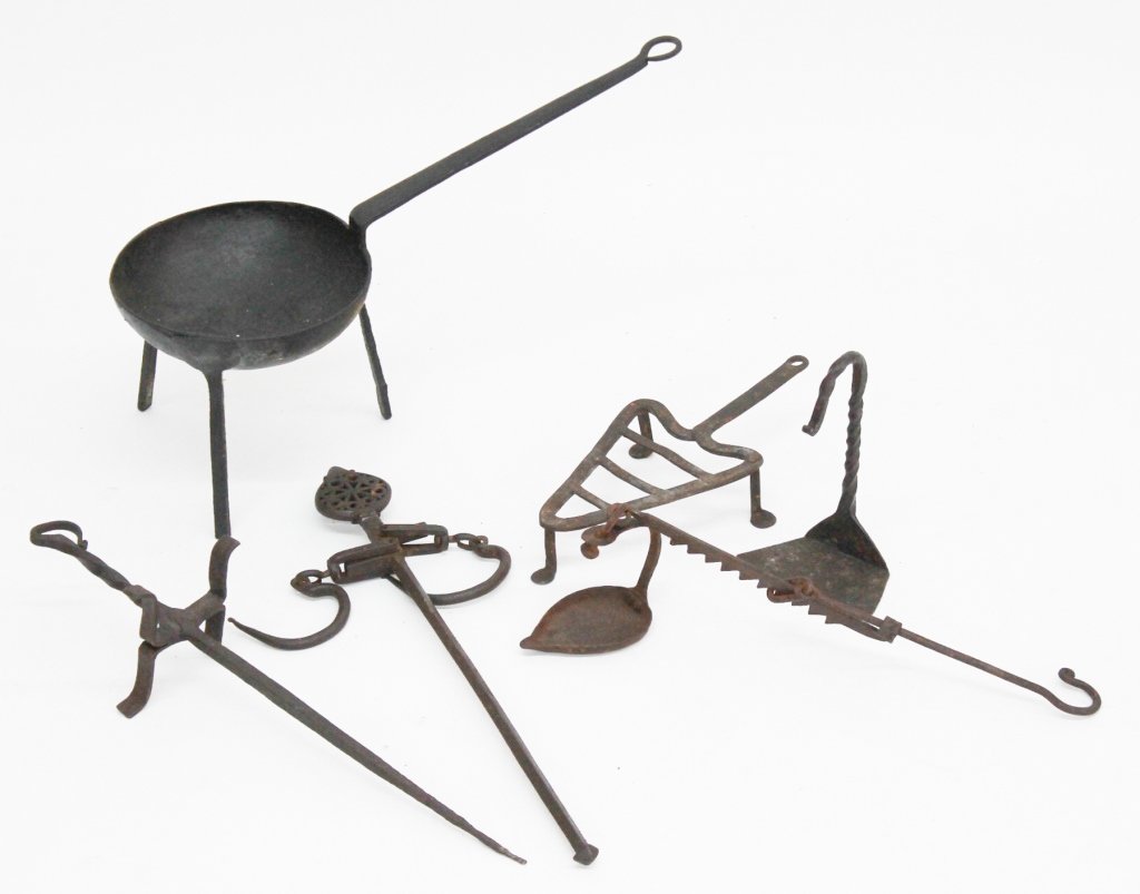Collection Early Wrought Iron Tools: 18th century, America or Britain. consisting of a fat lamp, four hearth cooking trivets and a Moravian iron scale.