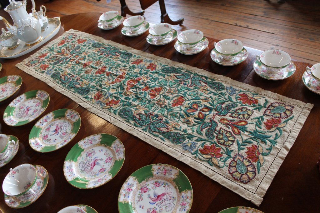 Two Antique American Needlepoint Table Runners: 19th century. the larger example is said to be Midwestern origin. it exhibits brilliant flora and fauna decoration with birds around the edge, on homespun fabric. L49 7/8" W14 3/4" L32 1/4" W15 3/4" F