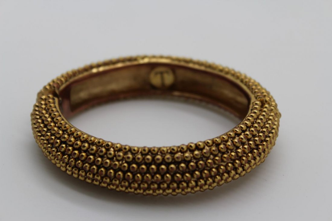 Vintage Gold Tone Textured Trifari Bangle Bracelet: Vintage gold tone chunky Trifari bangle bracelet Textured throughout with a magnetic closure & safety closure Measures 9 1/2" & 1" across Signed T inside bracelet Good vintage condition