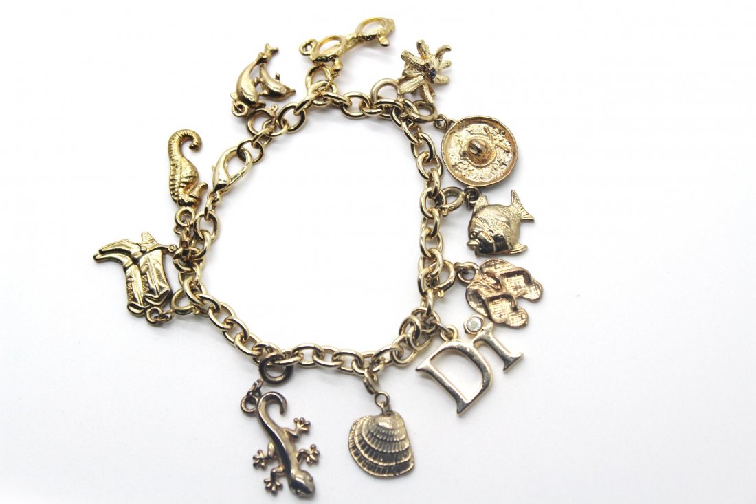 110: Vintage Gold Tone Charm Bracelet: Adorable charm bracelet with seashell, boots, horseshoe, dolphin. 11 charms. 7 3/4".
