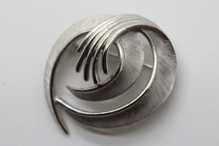 203: Vintage Trifari Silver Swirl Pin Brooch: Signed Trifari. Silvertone textured swirl pin/brooch. 1 1/2" in diameter.