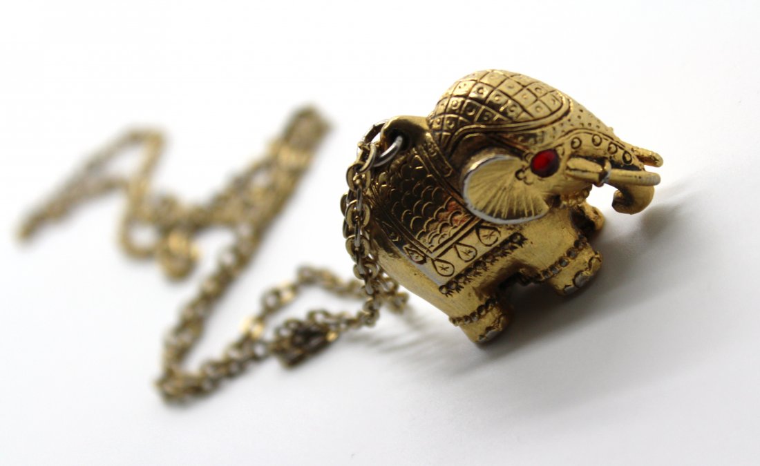 347: Vintage Gold Tone Elephant Locket Necklace: 16". Gold tone with red jeweled eyes. Locket opens