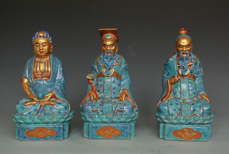 Three Robin's-Egg Blue and Gilt Buddhist Figures: 19th Century Comprising a Buddha holding a pearl in his lap dressed in long robes; an immortal with a fan; and an immortal with a ruyi sceptre, each seated on a double lotus and square plinth base. He