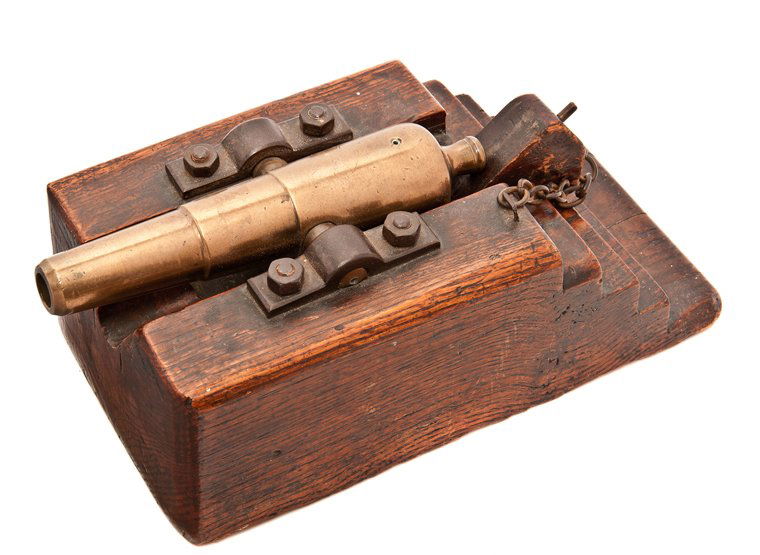 A MODEL CANON, CIRCA 1860 constructed in brass with 8in: A MODEL CANON, CIRCA 1860 constructed in brass with 8in. three-stage tapering barrel with touch hole, cascabel and trunnions, secured with iron staples to substantial stepped oak base with sliding ele