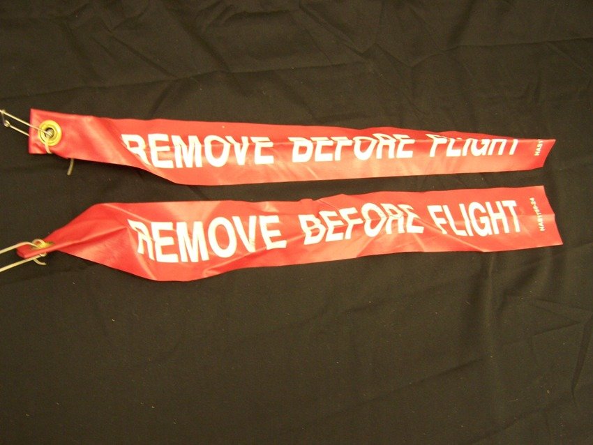Vintage Remove Before Flight Ribbon Collection: Lot of 2 that measure 24 in long From the estate of a Joel H. Taft a 40 plus year veteran of Grumman Aerospace Corporation