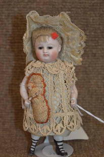 5 1/2" All Bisque Wrestler Doll: 5 1/2" All Bisque Wrestler Doll w/ blonde mohair wig, brown fixed eyes, closed mouth, wearing grey dress w/ crocheted overlay dress, holding 1" small doll on crochet bag, molded shoes & socks, 4 strap