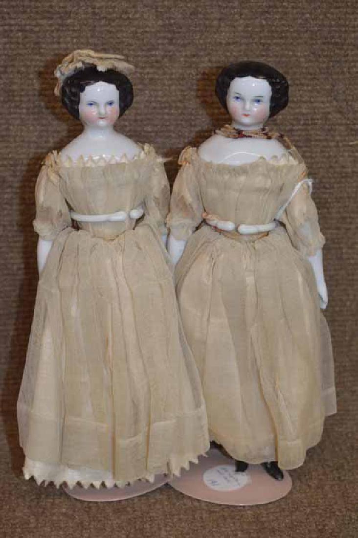 Pair of Flat Top Shoulder Head Twins.: Pair of Flat Top Shoulder Head Twins. Both are 9 1/4" w/ blue eyes, black hair, china arms & legs on cloth bodies, flat soled boots, off white gauze dresses w/ glazed cotton underslips, one has white