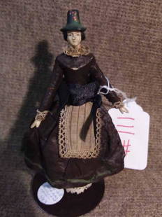 Wood Doll: 6 3/8" JTD CARVED WOODEN & PAPIER MACHE DOLL W/CARVED HAT, DELICATE BUT ALL ORIG COSTUME OF BLACK POLISHED COTTON W/GREEN EDGE TRIM & DELICATE APRON, BLACK HAT HAS MATCHING PTD TRIM, DARK ROSE MADDER