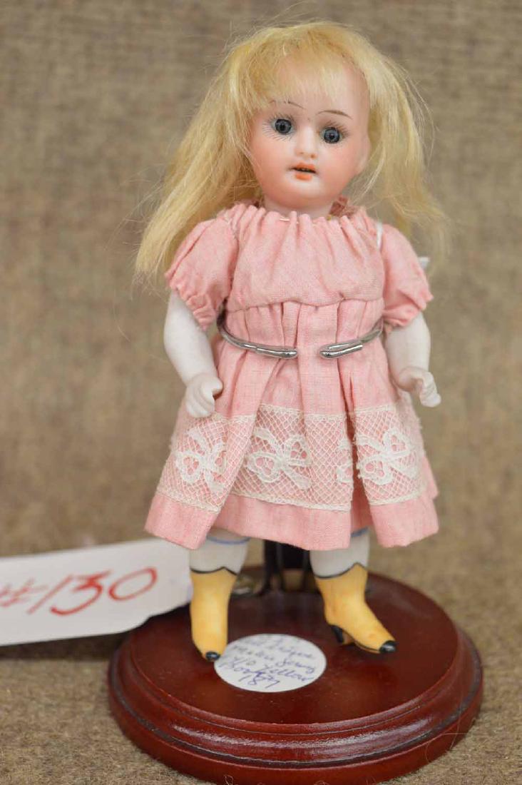 SWIVEL HEAD ALL BISQUE: 5 1/2" SWIVEL HEAD ALL BISQUE JTD AT SHOULDERS & HIPS, MARKED GERMANY 14/0, BLONDE MOHAIR WIG, SET BLUE EYES, O/M, MOLDED WHITE RIBBED SOCKS W/YELLOW BOOTINES W/ BLACK ACCENTS.