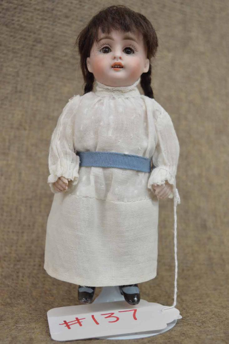 ALL BISQUE STIFF NECK: 7 1/2" ALL BISQUE STIFF NECK, MARKED 130 2 - DARK BROWN MOHAIR WIG W/BRAIDS, BROWN O/C EYES, O/M, JTD AT SHOULDERS & HIPS, WEARING WHITE COTTON DRESS, KNEE HIGH MOLDED PTD BLUE RIBBED SOCKS, SINGLE ST