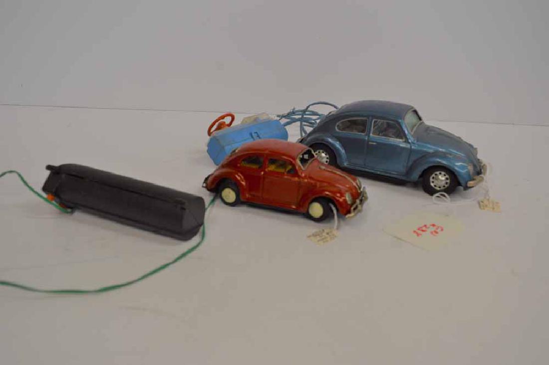 (2) VW BEETLES BATTERY OPERATED, TIN: (2) VW BEETLES BATTERY OPERATED, TIN, MADE IN JAPAN, BOTH WORK, LARGEST IS 8 1/4"L X 3"H X 3"W, SOME FRAYING ON WIRE, SOME SCRATCHING ON CARS