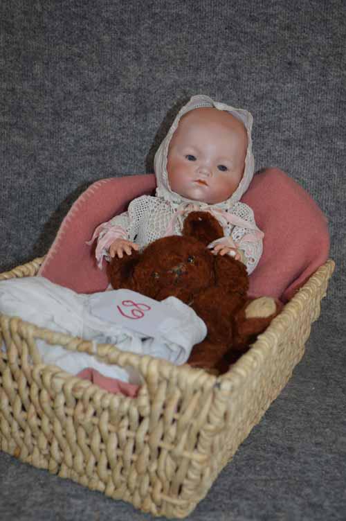 16" A.M. DREAM BABY: 16" A.M. DREAM BABY BISQUE HEAD ON "FROG" BODY, GRAY O/C EYES, SMALL RUB TO NOSE, CHIN AND (R) CHEEK, MISSING RING FINGER ON (L) HAND, WEARING BONNET AND LONG CHRISTENING DRESS, COMES W/OLD BROWN TEDD