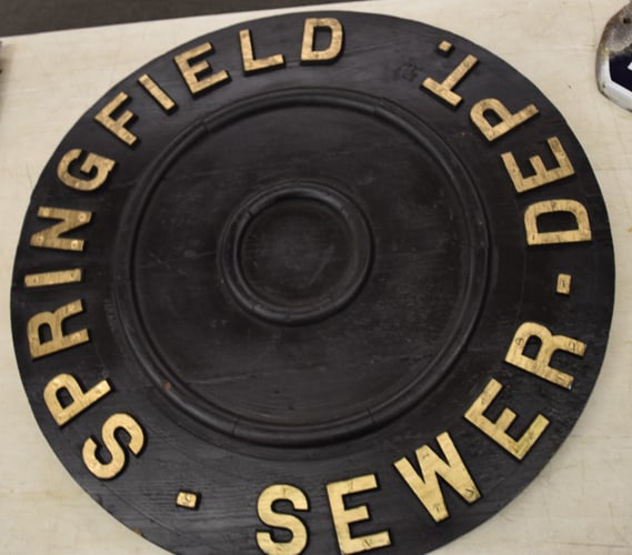 SPRINGFIELD SEWER CAP: SPRINGFIELD SEWER DEPARTMENT ROUND PAINTED WOODEN SEWER CAP