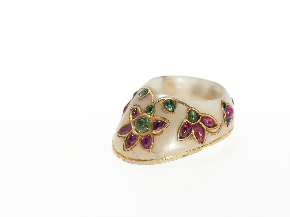 Kundan Jade Archer’s Ring, Mughal Empire, India, 17th: Pale green jade India, Mughal Empire, 17th Century Floral decor in kundan technique Inlaid emeralds and spinels Height: 4.2 cm Ring size: 67 Very good state of preservation Provenance: ex-collection F