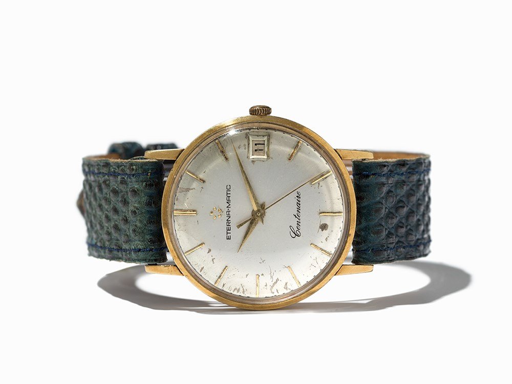 Eterna Eternamatic Centenaire Wristwatch, Around 1955: Eterna Eternamatic Centenaire wristwatch Switzerland, around 1955 Automatic movement, calibre 1438U; 21 jewels, hour, minute, second, date Silver dial, gold hands Watch case of 18K gold Blue leather s