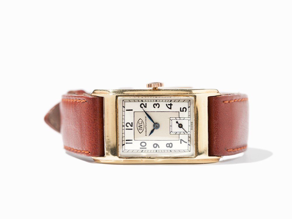 IWC Early Wristwatch, Switzerland, Around 1940: IWC early wristwatch Switzerland, around 1940 Manual wind movement, calibre 87; hour, minute, second Silver dial, blued hands Watch case of 18K gold Brown leather strap with pin buckle Watch case no.