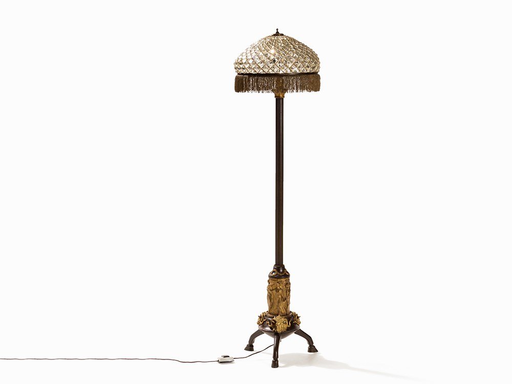 Crystal Glass Floor Lamp with Antique-Like Stand,: Gilt and patinated bronze, brass, brocade threads, cut crystal glass Presumably Germany, around 1930 Stand with three goat's feet, base with three dimensional ram's heads, above antique-style figural