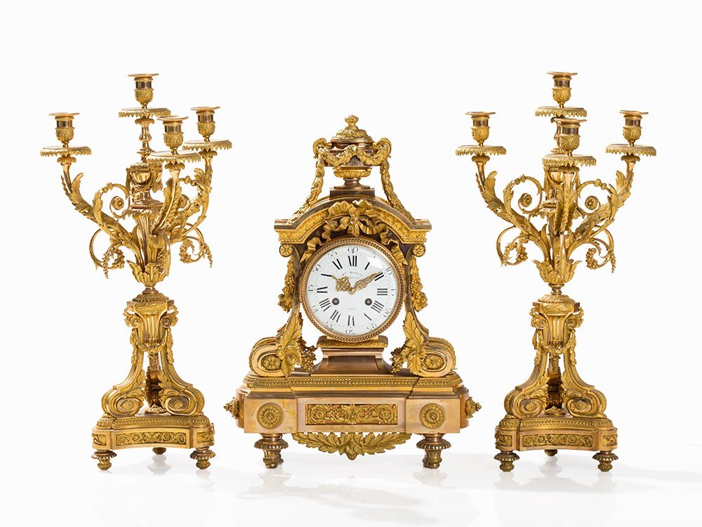 A French Ormolu Clock Garniture by Maison Marquis, 19th: Gilt-bronze, brass movement, enamel, glass Paris, Maison Marquis, Languereau, second half of the 19th century Signed round Marti movement, spring balancer, lever escapement 8 day duration half hour st