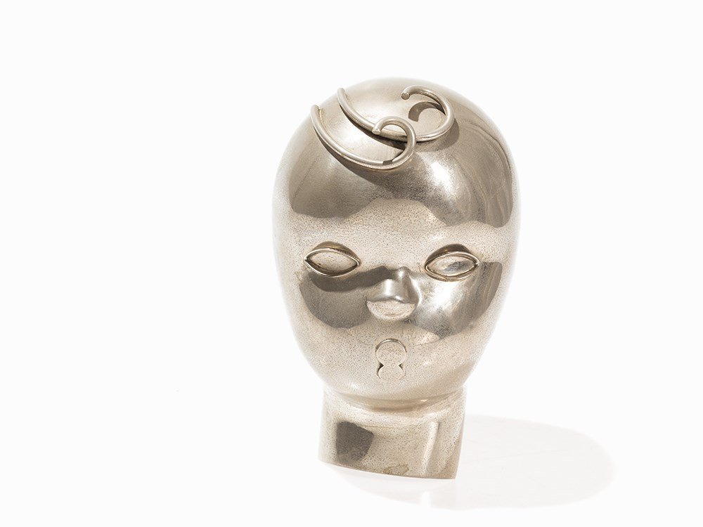 A Karl Hagenauer Figural Wall Mask, Germany, circa 1930: White metal, cast Germany, circa 1930 Design: Karl Hagenauer (1898-1956) - Austrian designer and sculptor Execution: Hagenauer Werkstätte Wien (1898-1987) Hollow-worked mask of a child with stylized