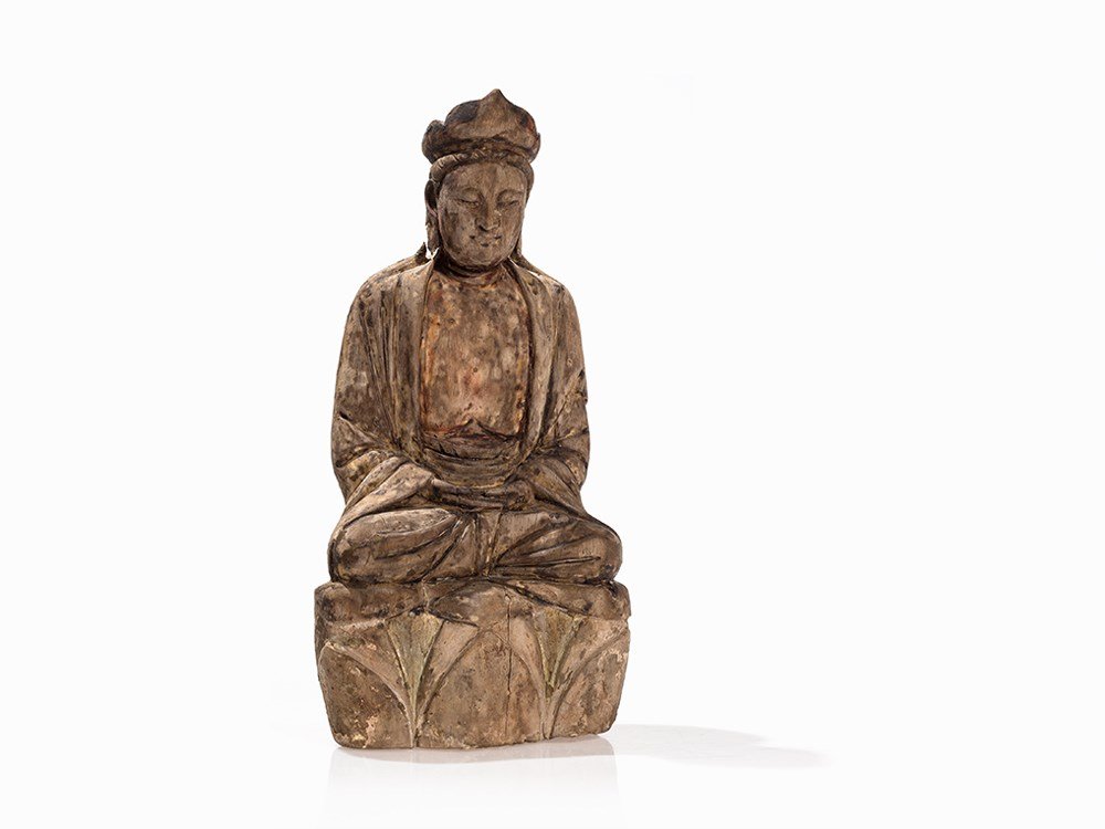 Wooden Figure of a Boddhisatva Guanyin on a Lotus: Wood, traces of color and gold painting China, Ming dynasty (1386-1644) Depiction of Guanyin, who is known as the goddess of goodwill in the padmasana lotus position Shown in deep meditation with half