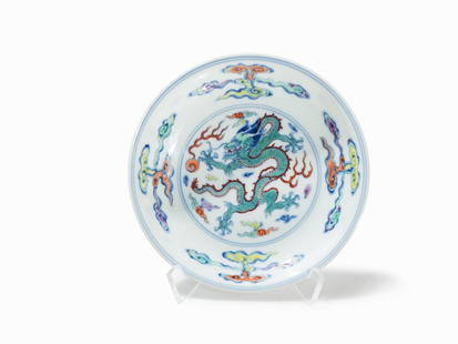 Doucai Dish with Dragon and Pearl, Yongzheng Mark &: Porcelain with polychrome painting China, Yongzheng period (1723-1735) Wide dish on a round base rim In the centre a fine painting of a five clawed dragon with turquoise scales and a flaming magical p