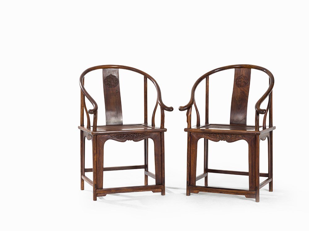 Pair of Huanghuali Horseshoe Chairs with Chilong: Dalbergia ssp. China, Qing dynasty (1644-1911) Horseshoe shape with slightly curved and ornate back splat Back splat with a Ruyi shaped reserve in relief carving with a Chilong dragon among clouds At 