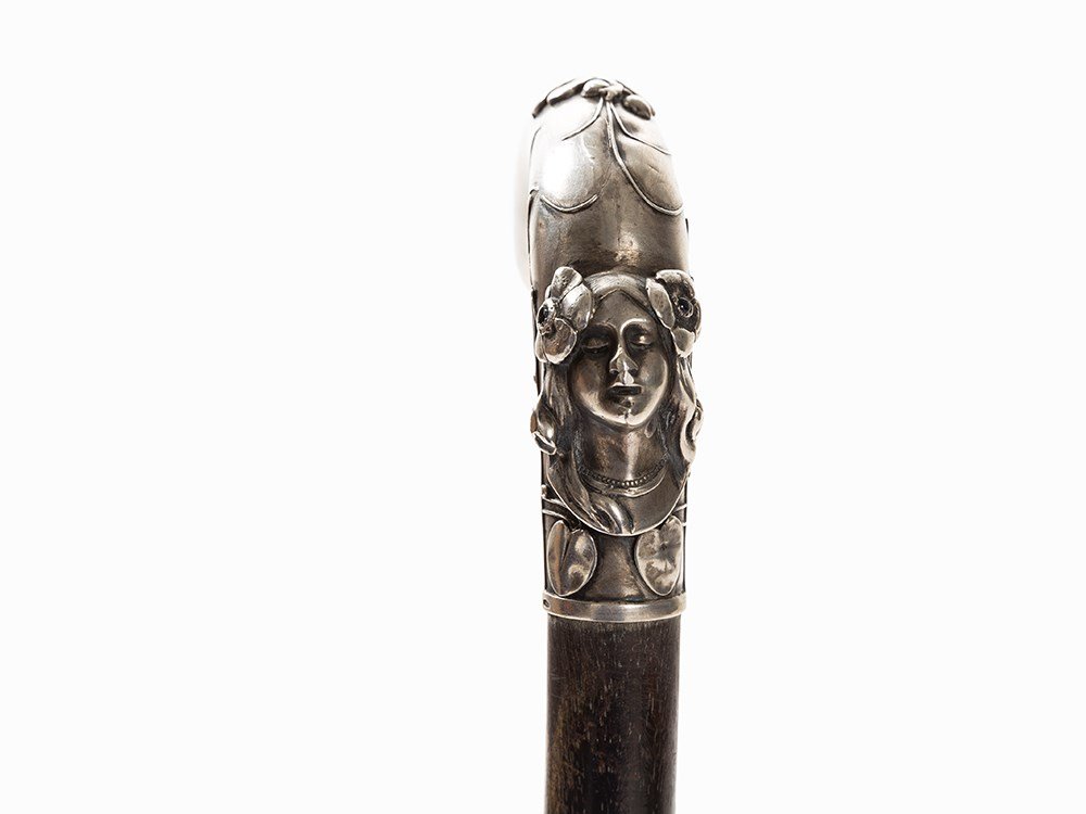 A Dandy Cane with Art Nouveau Silver Handle, Austria,: 800 silver, cast, die, wood, ebonized, metal, glass stones Austria, c. 1900 Hallmarked with silver standard 800 silver and further illegible hallmark Conically tapered shaft Tip of white metal Silver 