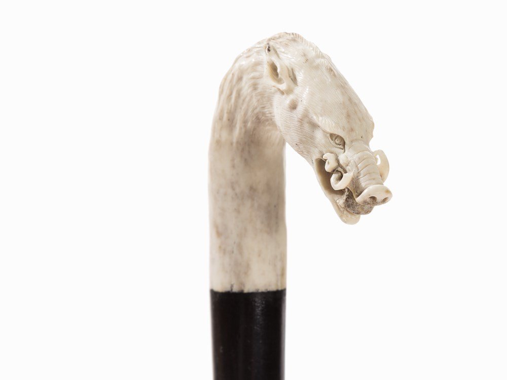 A Cane with Boar’s Head Handle, pres. Austria, 19th C: Bown, carved, wood, ebonized Presumably Austria, 19th century Smooth, conically tapered shaft (presumably added later or re-painted) with pierced bone plaque with hunting motif Handle sculpted in the 